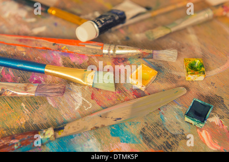 Eine kleine Sammlung von Kunstmaterial auf einer Holzpalette Stockfoto