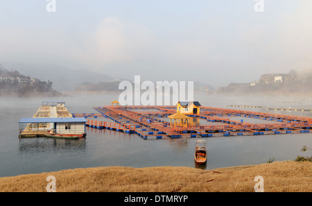 Landschaft von schwimmenden Boot am Seeufer in einem nebligen Morgen Stockfoto