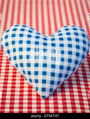 Blaues Herz auf karierte Tischdecke Stockfoto