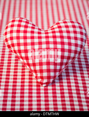 Rotes Herz auf karierte Tischdecke Stockfoto