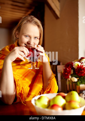 Junge Frau ist Tee trinken und lächelnd. Stockfoto