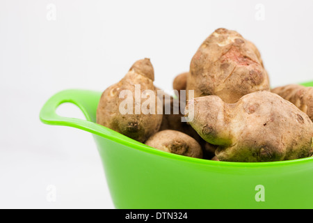 Helianthus Tuberosus. Topinambur in einem grünen Sieb. Stockfoto