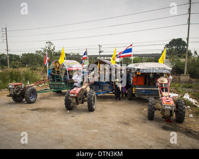 Khlong Chik, Phra Nakhon Si Ayutthaya, Thailand. 21. Februar 2014. Farmers Traktoren geparkt auf der Seite der Highway 32 während einer Autokolonne ging nach Bangkok. Etwa 10.000 thailändischen Reisbauern, Reisen in fast 1.000 Traktoren und landwirtschaftliche Fahrzeuge, blockiert Autobahn 32 in der Nähe von Bang Pa In Provinz Phra Nakhon Si Ayutthaya. Die Bauern waren unterwegs zum Flughafen in Bangkok, um gegen die Regierung zu protestieren, weil sie Reis die Regierung bezahlt wurde noch nicht von ihnen letztes Jahr gekauft. Die Bauern drehte sich um und ging nach Hause, nachdem sie mit Regierungsbeamten, die die Bauern Zahlungszusage nex Stockfoto