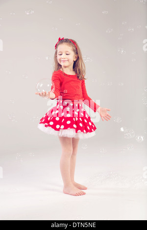 Lustig, schöne kleine Frau, die das Spiel mit Seifenblasen Stockfoto