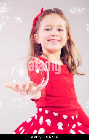 Kleine Frau, große Seifenblasen machen Stockfoto