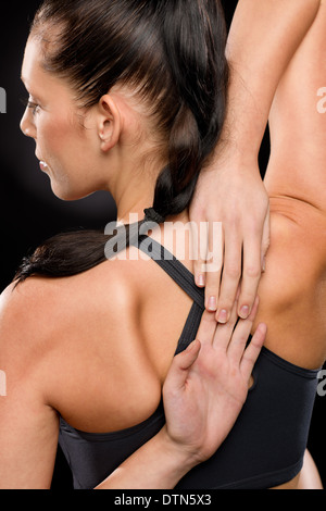 Junge Frau, die ihre Arme und Rücken dehnen Stockfoto
