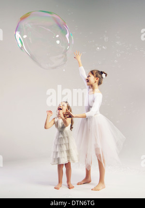 Zwei Mädchen mit den großen Seifenblasen Stockfoto