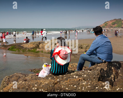 Indien, Goa, Vagator Beach, indische Touristen saßen auf den Felsen der Küste Stockfoto