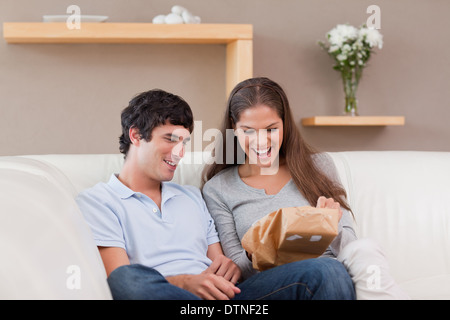 Paar auf der Couch mit Paket Stockfoto