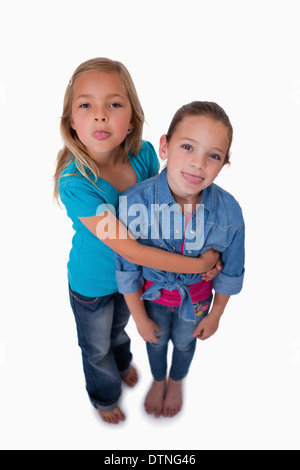 Porträt von Mädchen, die ihre Zungen herausragen Stockfoto