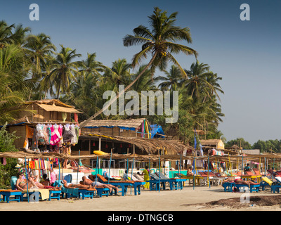 Indien, Goa, Morjim, Vithaldaswada Strand, Touristen, Sonnen auf Sonnenliegen Stockfoto