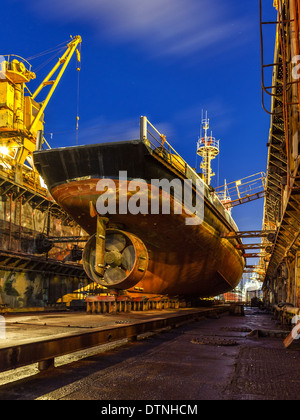 Schiffsreparatur im Trockendock in der Nacht. Stockfoto