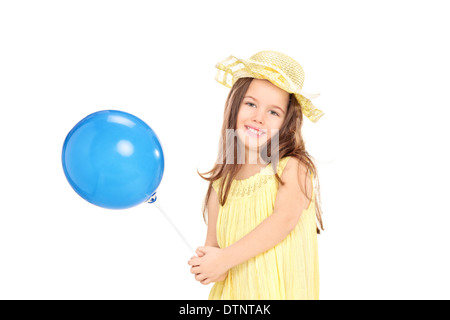 Niedliche kleine Mädchen im gelben Kleid hält einen blauen Ballon Stockfoto