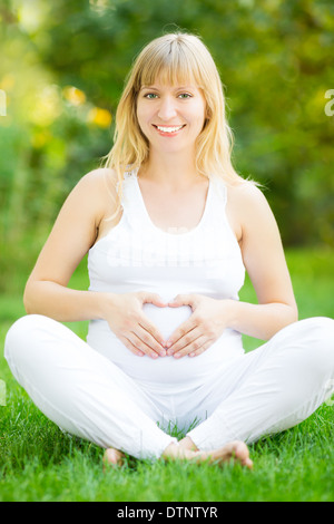 Schwangere Frau Hand in Hand auf Bauch Stockfoto