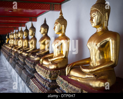 Reihe von Buddha-Statuen im Tempel Wat Pho in Bangkok, Thailand aufgereiht. Stockfoto