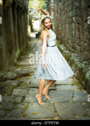 Schöne, glückliche kaukasischen Frau trägt eine Krone aus Blumen, tanzen barfuß in einem magischen, märchenhafte Ambiente. Stockfoto