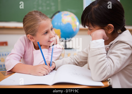 Niedliche Schulmädchen tun Klassenarbeiten Stockfoto