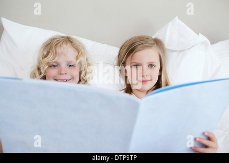 Bruder und Schwester lesen Gutenachtgeschichte Stockfoto