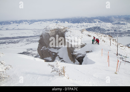 Skifahrer stehen am Rande des Corbets Coulouir, ein double Black Diamond Skirun, Jackson Hole, WY Stockfoto