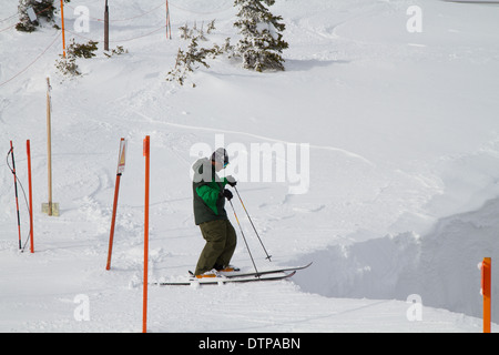 Skifahrer stehen an der Kante Corbet Coulouir, Jackson Hole, WY Stockfoto