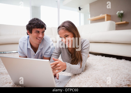 Paar mit Laptop auf dem Teppich Stockfoto