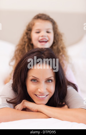 Mädchen genießt auf dem Rücken der Mutter sitzen Stockfoto