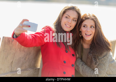 Glückliche junge Frauen Foto mit Handy Stockfoto