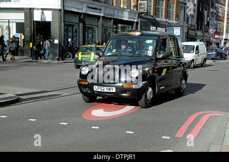 Schwarzes Taxi Cab Eingabe Umweltzone mit C gemalt auf Straße, Engel, Islington, London England UK Stockfoto