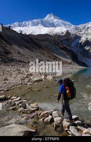 Überqueren den Auslass des Birendra Tal (See Birendra), Nepal Trekker. Manaslu Peak ist im Hintergrund. Stockfoto