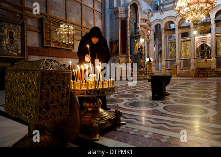 Ein christlich-orthodoxer Gläubiger zündet während einer Massenprozession über den Omphalos im griechisch-orthodoxen Katholikon oder der Katholikon-Kapelle in der Grabeskirche in der Altstadt von Jerusalem Israel Kerzen an Stockfoto