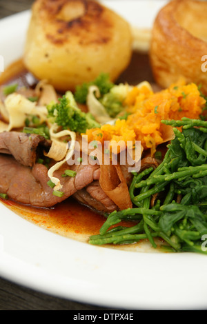 Gebratenes Rindfleisch Abendessen mit Bratkartoffeln, Yorkshire Pudding und Gemüse püriert Schwede und Queller Stockfoto