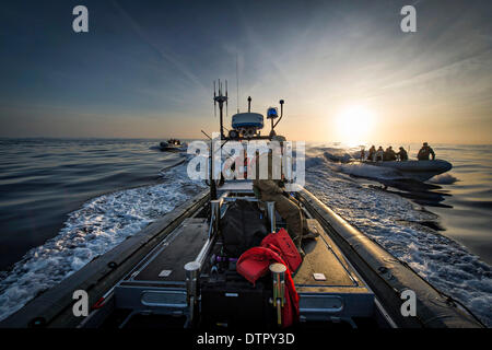 US Navy Segler und Taucher aus der amphibischen Transportschiff der Dock USS San Diego Operationen Boot beim ersten Test am Meer Erholung für das Orion Crew Modul für NASA Orion-Programm 20. Februar 2014 im Pazifischen Ozean. Stockfoto