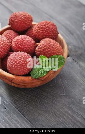 Frische Lychee in Schüssel auf einem hölzernen Hintergrund Stockfoto