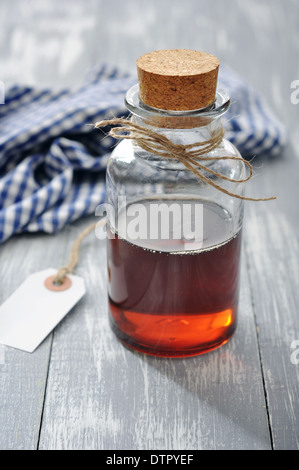 Ahornsirup in Glasflasche auf einem hölzernen Hintergrund Stockfoto