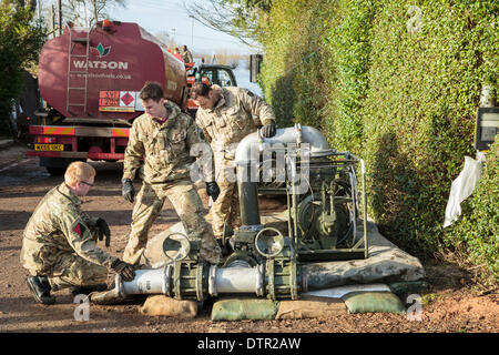 Burrowbridge, UK. 22. Februar 2014. Eine neue Pumpe mit dem Merlin Hubschrauber eingeflogen wird durch Armee-Kommandos an Burrowbridge am 22. Februar 2014 operative gemacht. Die Pumpe liefert Saltmoor Pumping Station, von der Umweltagentur mit Dieselkraftstoff betrieben, für seine Addiitional-Wasserpumpen, die installiert wurden, entfernen Sie das hohe Volumen der Flut aus den umliegenden Feldern rund um Northmoor und Dorf von Moorland Wasser und Pumpen Sie ihn in den Fluß Parrett, wo es von der Flut hingerissen ist. Dies ist die schlimmsten Überschwemmungen auf der Somerset Levels in lebendige Geschichte. Stockfoto