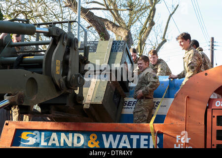 Burrowbridge, UK. 22. Februar 2014. Kommandos helfen bei Burrowbridge auf den überfluteten Somerset Niveaus am 22. Februar 2014. Eine Gruppe von Soldaten laden Kisten von Lieferungen auf einer Umweltagentur Trac-Dumper, einem spezialisierten Fahrzeug durch tiefes Wasser zu gehen. Versorgung mit Erdöl und mechanischen Teile werden an Saltmoor Pumping Station geschickt wo Wasser aus Northmoor in den Gezeiten-Fluß Parrett zu entlasten, das überschwemmte Gebiet gepumpt wird. Das sind die schlimmsten Überschwemmungen auf der Somerset Levels in lebendige Geschichte. Stockfoto