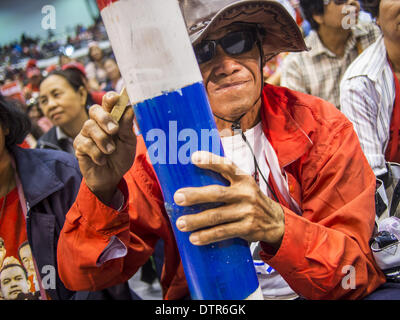 Nakhon Ratchasima, Thailand. 23. Februar 2014. Ein rotes Hemd Unterstützer in Korat. Die Einheitsfront der Demokratie gegen den Diktator (UDD oder Red Shirts), die die gewählte Regierung von Yingluck Shinawatra, inszeniert unterstützt die "UDD klingende der Schlacht Trommeln '' Rallye in Nakhon Ratchasima (Korat) gegen die Anti-Regierungs-Proteste, die Bangkok seit November gegriffen haben. Rund 4.000 der UDD Regionen und Provinzen Koordinatoren zusammen mit der Organisation Kernmitglieder trafen sich in der Liptapunlop Hall in seiner Majestät des Königs der 80. Geburtstag Jubiläum Sports Complex Stockfoto