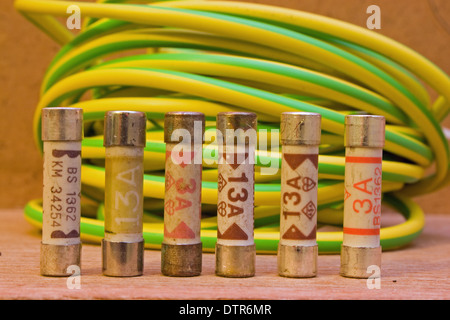 Reihe von Haushalt elektrische Sicherungen mit einer Spule der Erde Kabel Sleeven im Hintergrund. Stockfoto