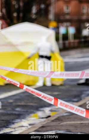 Belfast, Nordirland, Zelt 23. Februar 2014 - Polizei Band bildet ein Cordon außerhalb der Tatort eines Verbrechens mit einem Forensik-Offizier stehend vor Untersuchungsbeginn Credit: Stephen Barnes/Alamy Live News Stockfoto