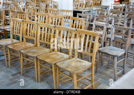 Sitzen unbequem: harte hölzernen Sitzreihen aufgereiht in einer Kirche. Stockfoto