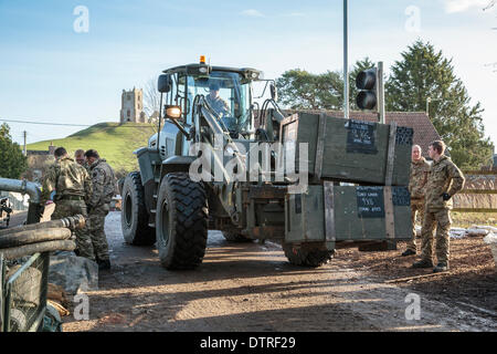 Burrowbridge, UK. 22. Februar 2014. Kommandos helfen bei Burrowbridge auf den überfluteten Somerset Niveaus am 22. Februar 2014. Eine Gruppe von Soldaten bewegen Kisten mit Lieferungen für Saltmoor Pumping Station wo Wasser aus Northmoor in den Gezeiten-Fluß Parrett zu entlasten, das überschwemmte Gebiet gepumpt wird bestimmt. Schwertransporter und Pumpen haben in mit dem Hubschrauber zum humanitären Arbeit im Dorf Hilfe geflogen worden. Infanteriekompanien arbeiten an die A361-Brücke über den Fluß Parrett mit lokaler Grenzstein Graben prahlen im Hintergrund. Das sind die schlimmsten Überschwemmungen auf der Somerset Levels in lebendige Geschichte. Stockfoto