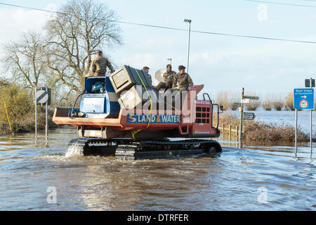 Burrowbridge, UK. 22. Februar 2014. Kommandos helfen bei Burrowbridge auf den überfluteten Somerset Niveaus am 22. Februar 2014. Eine Gruppe von Soldaten sind durch das Hochwasser von Arbeitern der Umweltagentur in Trac-Dumper, einem spezialisierten Fahrzeug gehen durch tiefes Wasser transportiert. Versorgung mit Erdöl und mechanischen Teile werden an Saltmoor Pumping Station geschickt wo Wasser aus Northmoor in den Gezeiten-Fluß Parrett zu entlasten, das überschwemmte Gebiet gepumpt wird. Das sind die schlimmsten Überschwemmungen auf der Somerset Levels in lebendige Geschichte. Stockfoto