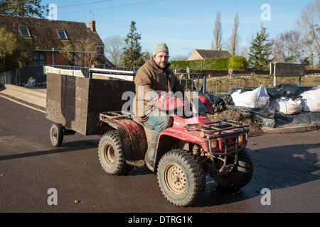 Kneipe Vermieter Jim Winkworth verwendet ein Quad mit Anhänger liefern Lieferungen und rette Tiere von den schweren Überschwemmungen in Burrowbridge am 22. Februar 2014. Als Vermieter von König Alfred Inn hat er auch Hochwasser gefährdeten aber hilft seit seinem Einheimischen mit Besorgungen während der Krise besuchen Dörfer von Moor- und Fordgate an den Ufern des Flusses Parrett Reisen. Stockfoto