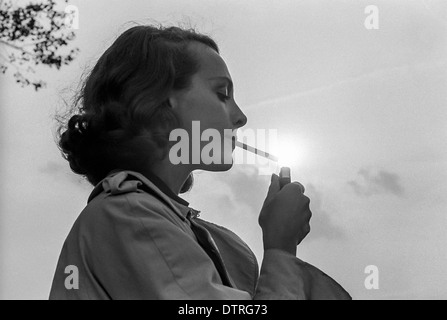 Junge Frau zündet sich eine Zigarette Stockfoto