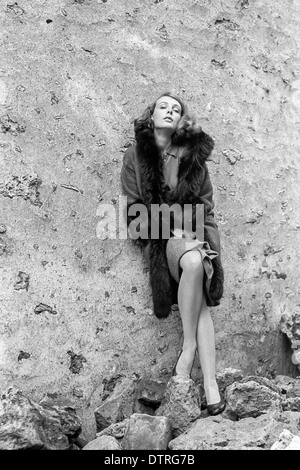 60er Jahre Mode Modell mit Pelz posieren gegen eine Wand Stockfoto
