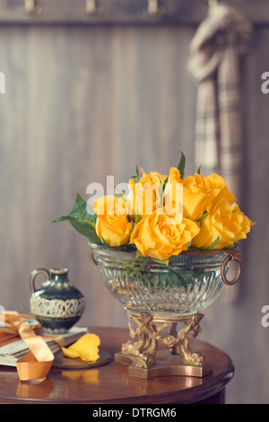 Land Haus Empfangshalle mit Tisch, geschmückt mit gelben Rosen in eine antike vase Stockfoto