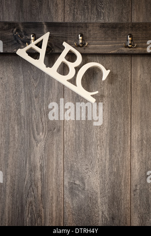 ABC Buchstaben hängen von Haken an getäfelten Wand Stockfoto