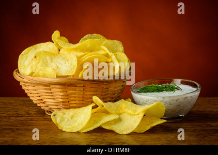 Stillleben mit Kartoffelchips und Dill-Dip-sauce Stockfoto