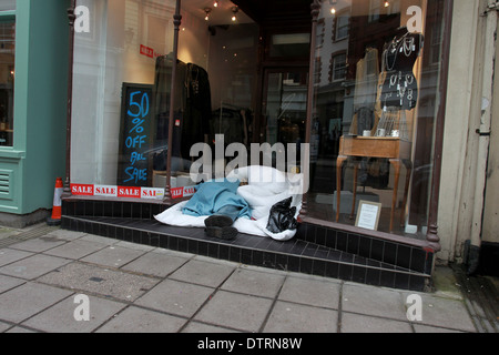 Ein Obdachloser abgebildet, schlafen in einem Kleidung Shop Eingang im Zentrum von Brighton, East Sussex, UK. Stockfoto