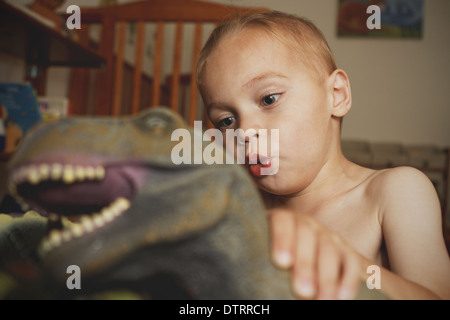 Jungen spielen mit Dinosaurier Stockfoto